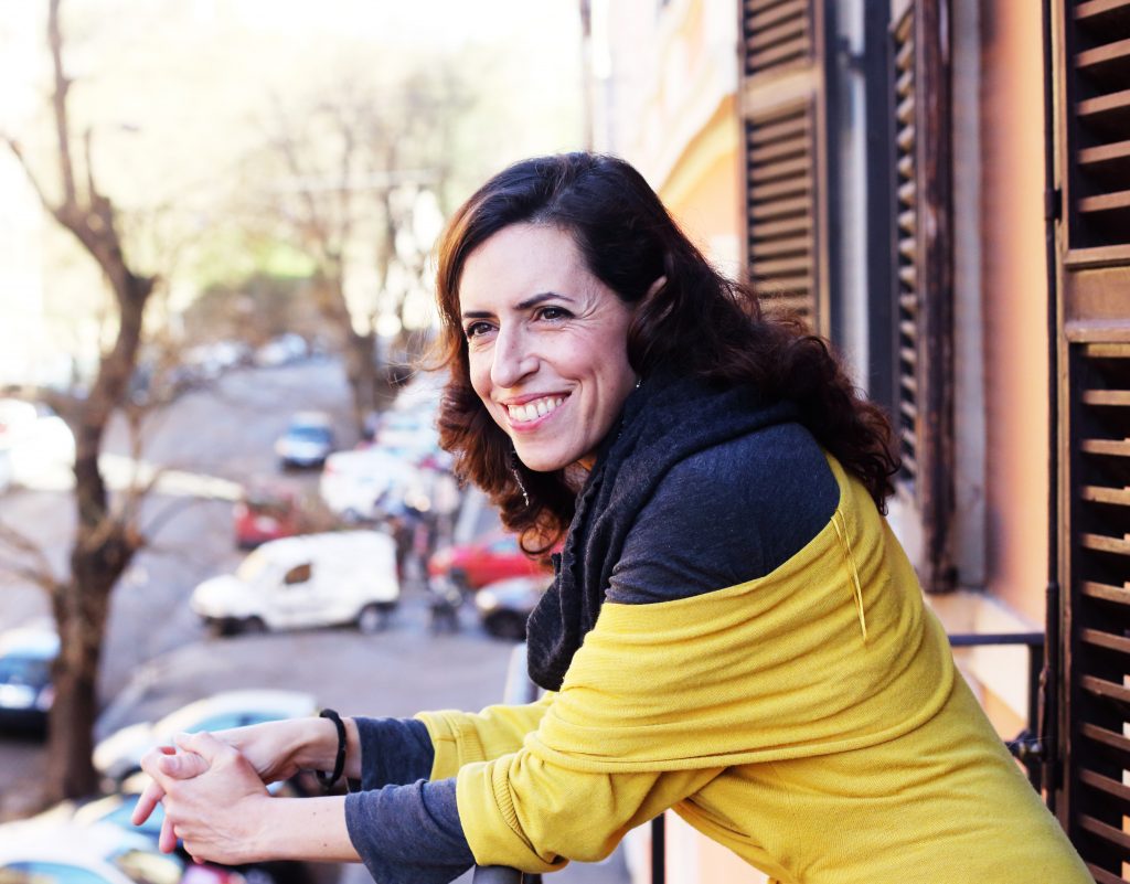 beautiful mature woman standing on the balcony looking to the street